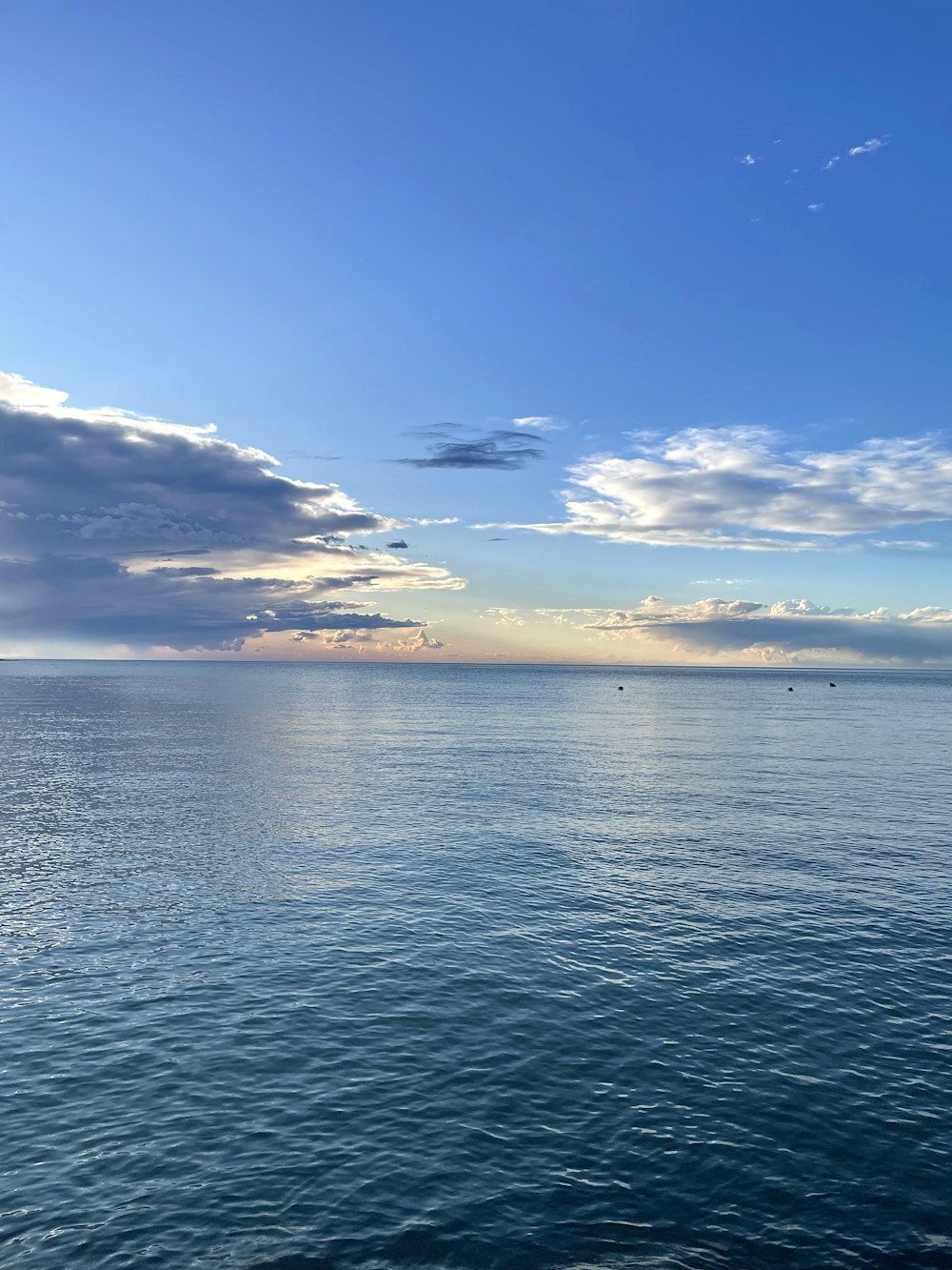 una gran masa de agua bajo un cielo azul nublado