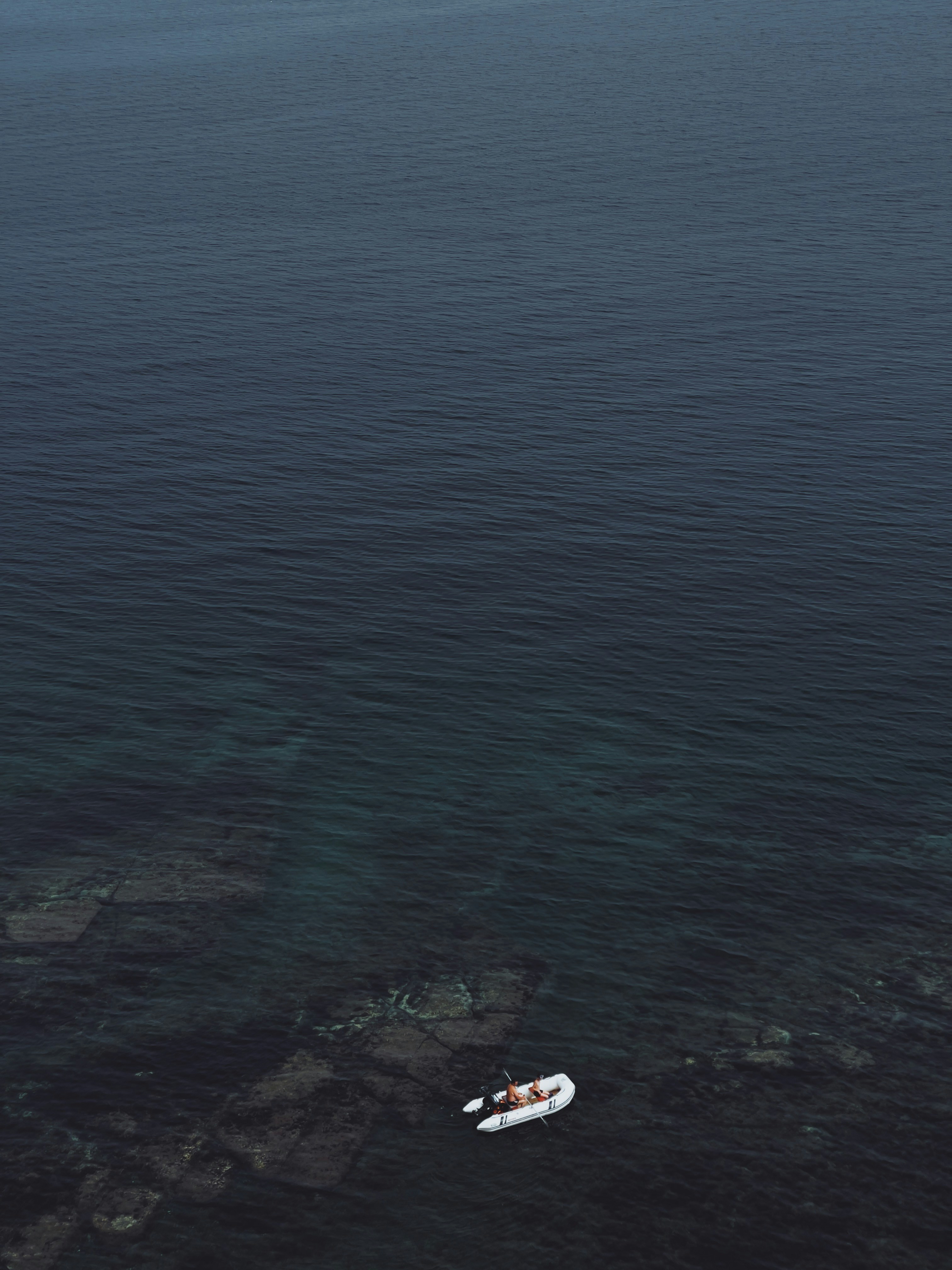 a small boat floating on top of a large body of water