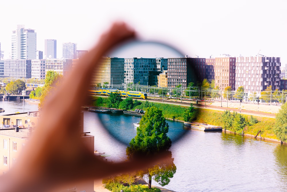 a person holding a magnifying glass over a river