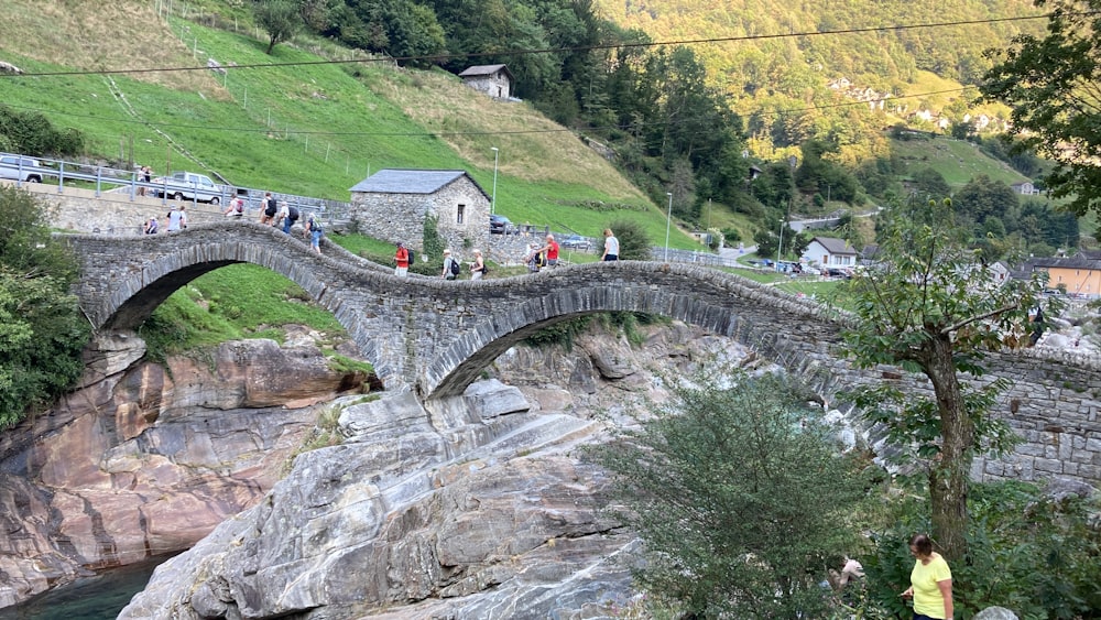 a group of people walking across a bridge over a river