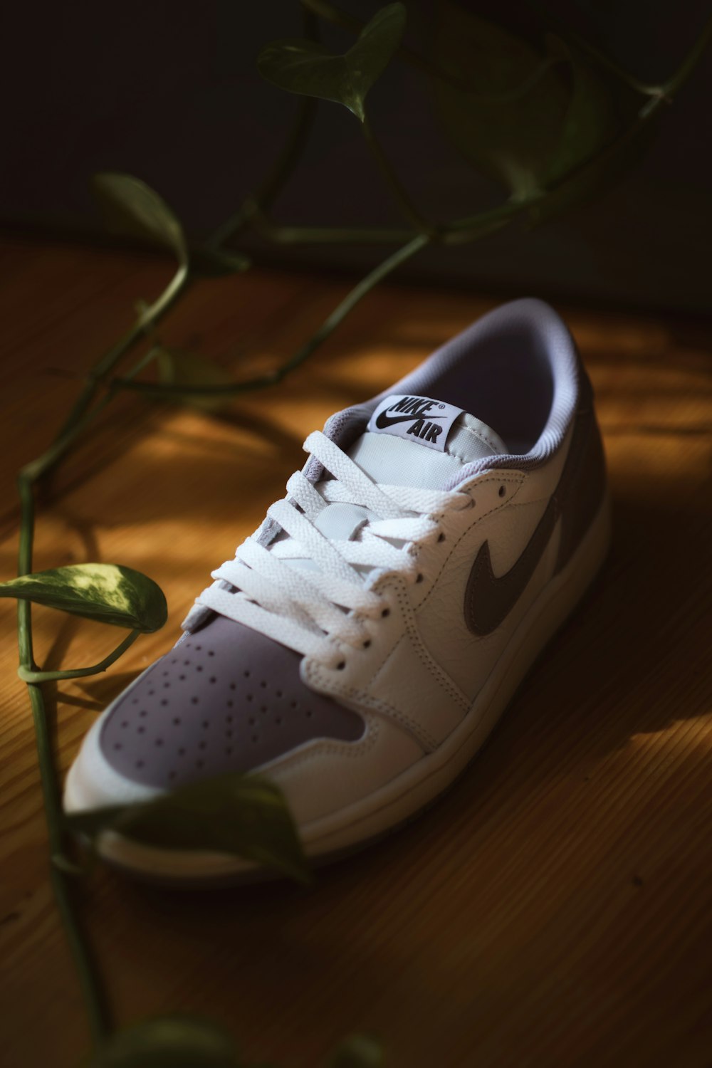 a pair of white shoes sitting on top of a wooden floor
