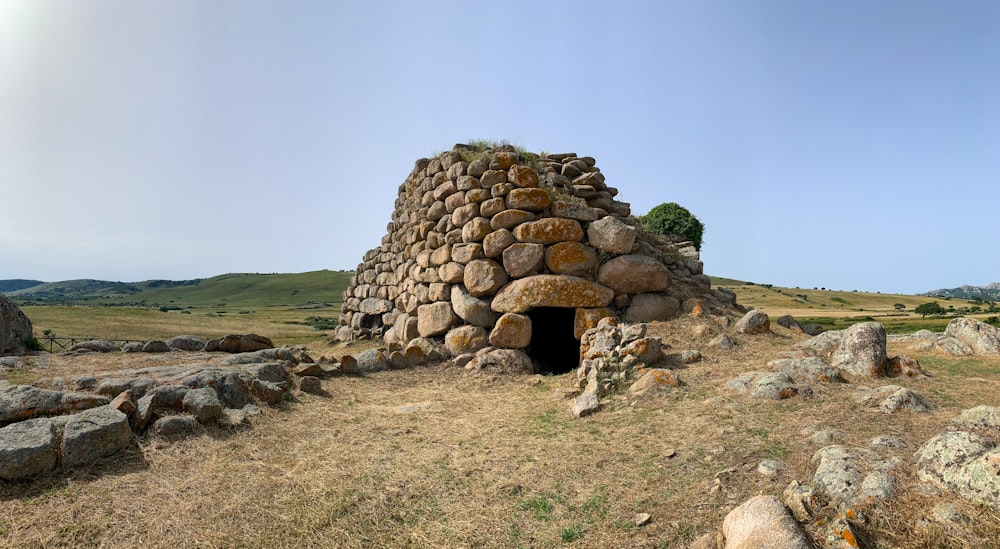 a stone structure made of rocks in the middle of a field