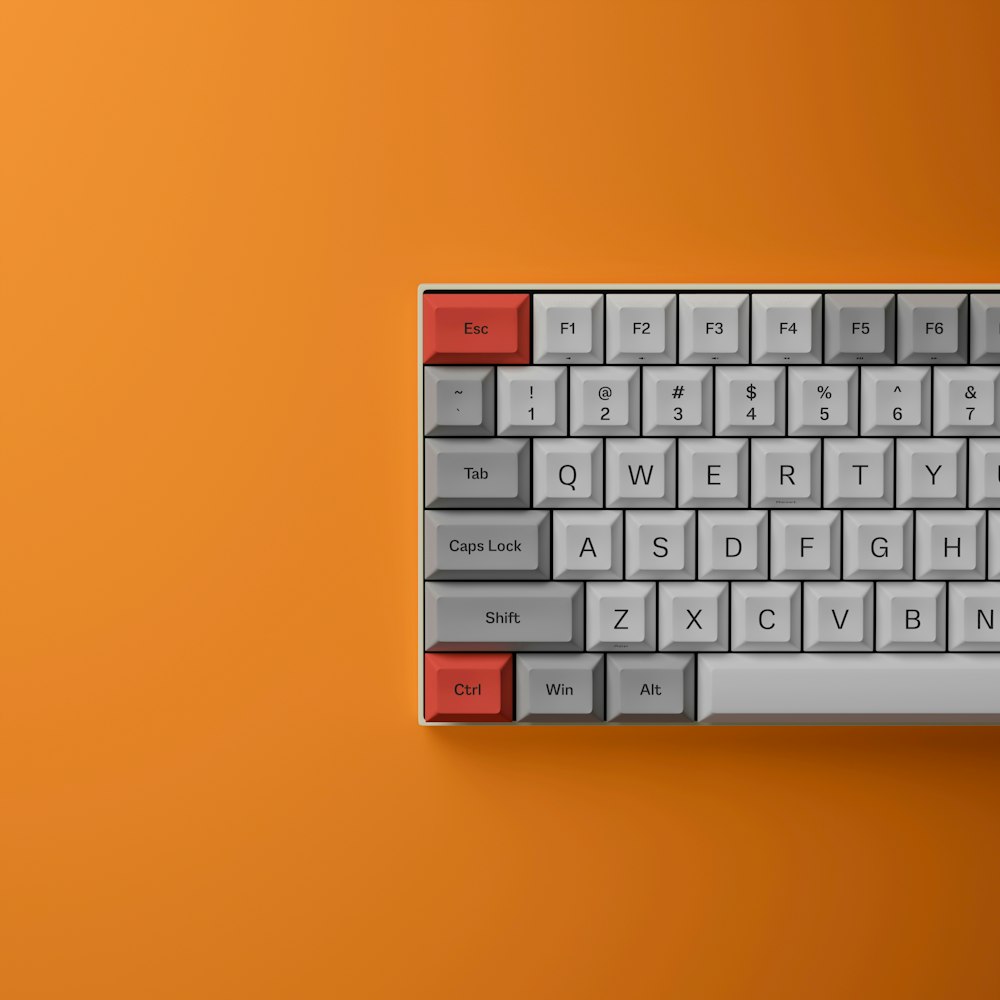 um teclado de computador em um plano de fundo laranja