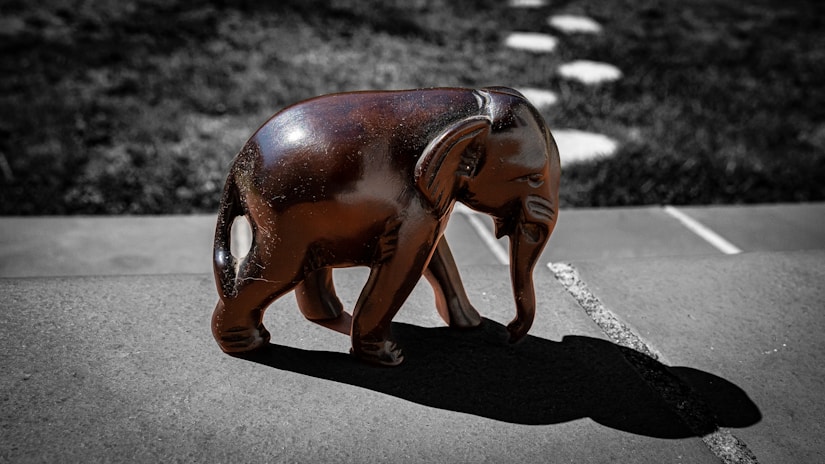 a statue of an elephant casting a shadow on the ground