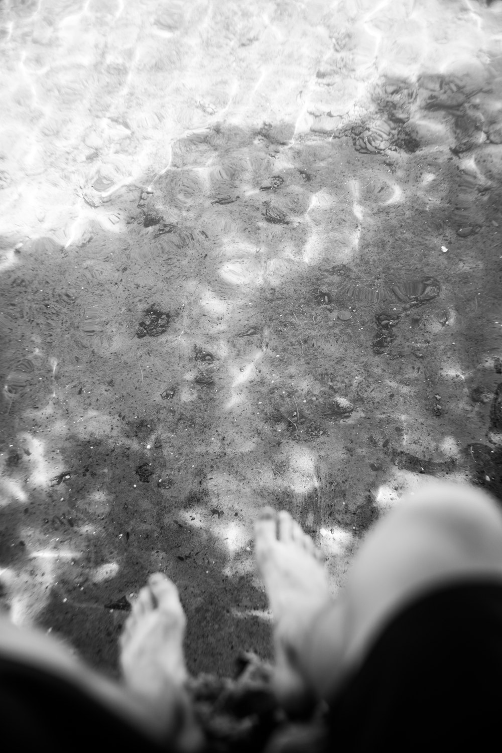 a black and white photo of a person's feet on the ground