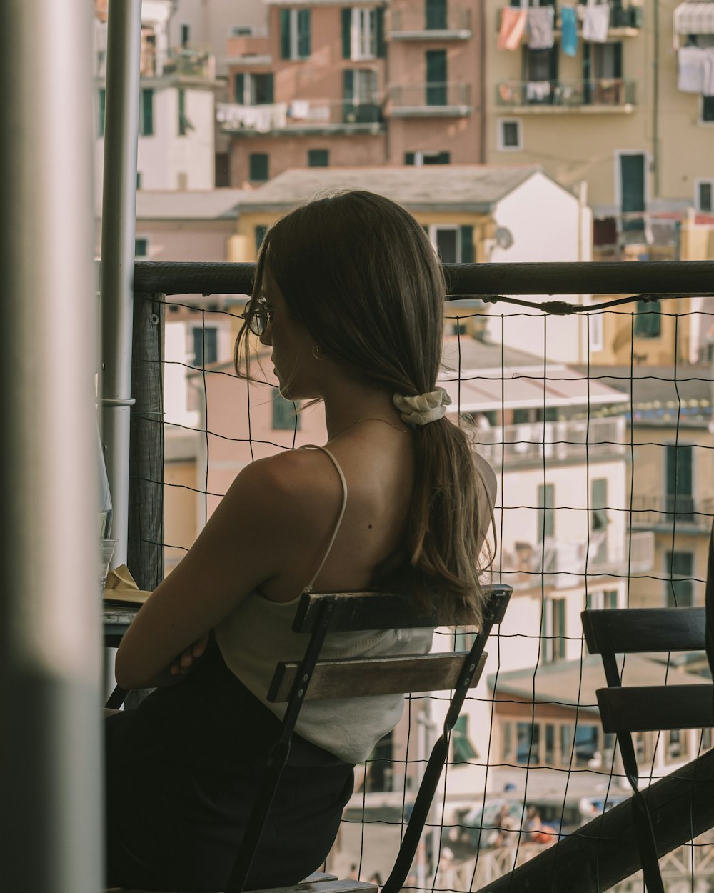 a woman sitting in a chair looking out a window