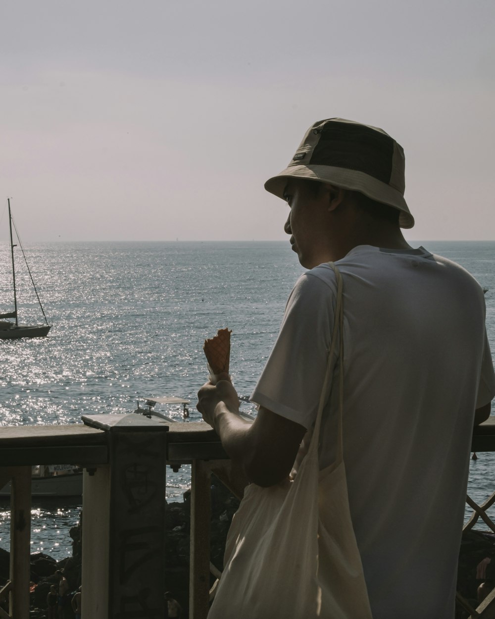 a man in a hat is looking out at the ocean