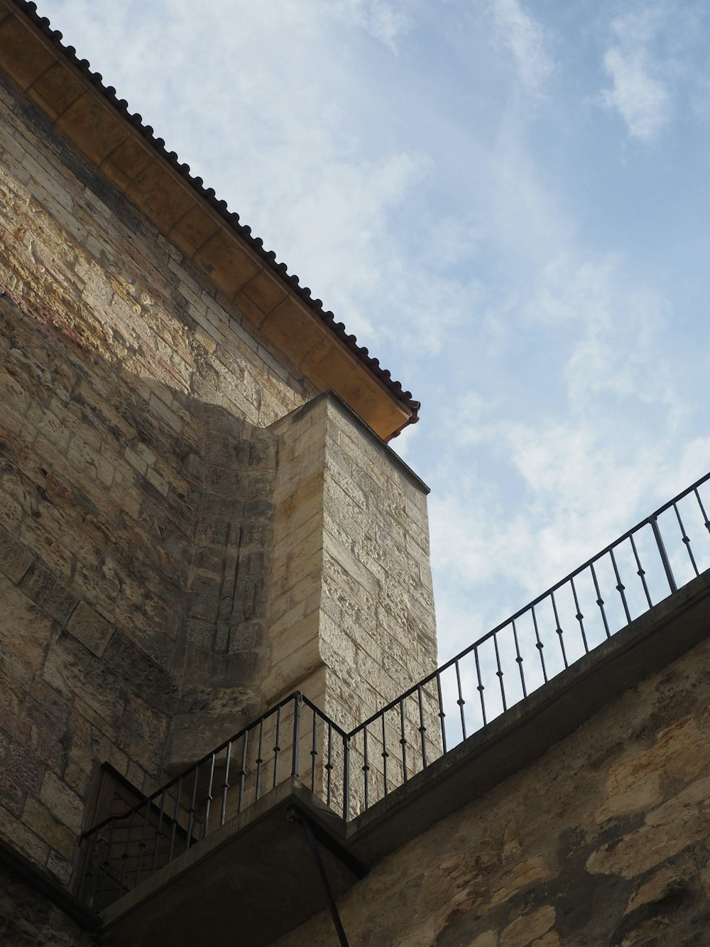 a stone building with a balcony and railing