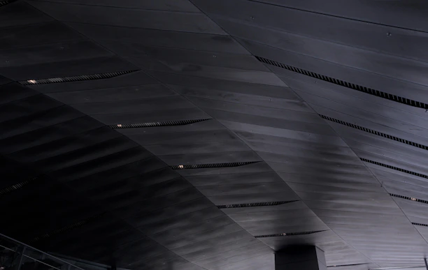 Close-up of sleek aluminum ventilation outlets installed in a modern commercial building ceiling.