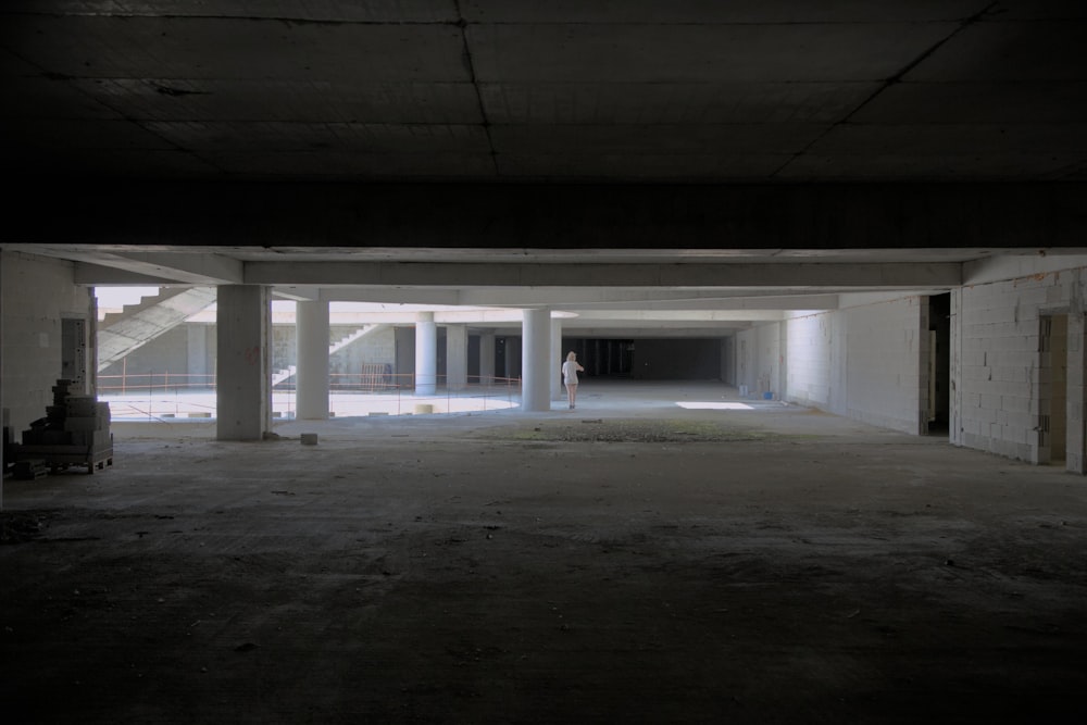 an empty parking garage with a person walking in it