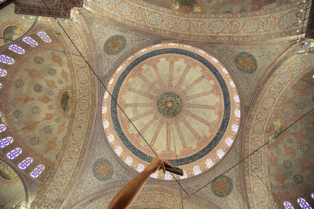 a person reaching up to the ceiling of a building