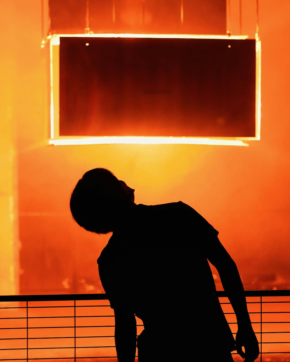 a silhouette of a person standing in front of a building