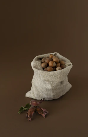 Natural humic acid fertilizer in a small burlap sack with soil background.