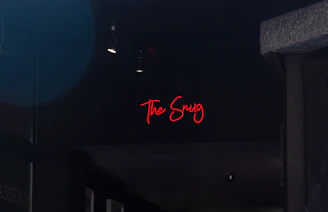 The warm, inviting interior of The Snug Bar lit softly during a lively game night.