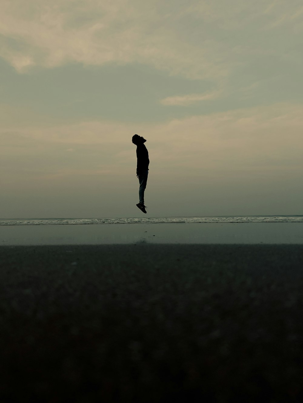 a person jumping in the air on a beach