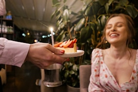A joyful woman enjoying a slice of healthy, homemade cake.
