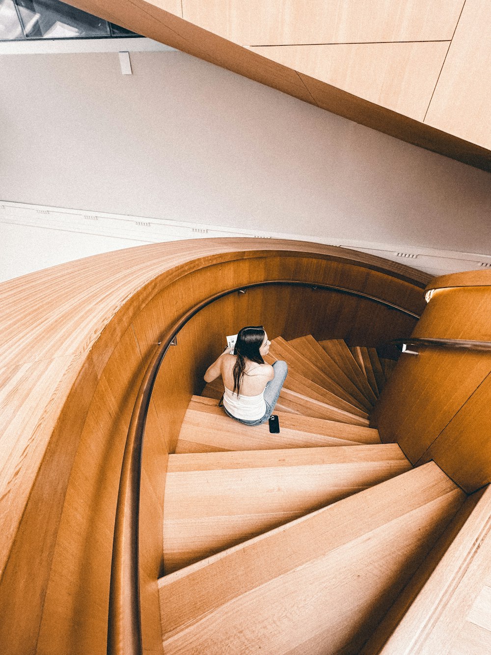 a woman sitting on top of a wooden staircase