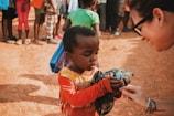 a woman is handing something to a child