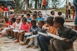 a group of children sitting on steps with books