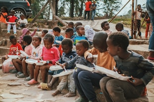 a group of children sitting on steps with books