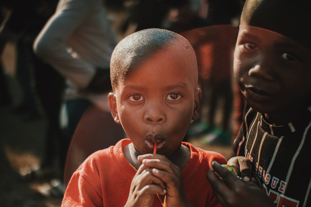 a boy with a shaved head eating something