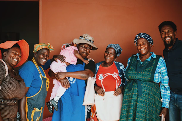 A group of women and children smiling together during a community health workshop.