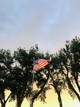 An American flag waving gently outside a military base at sunset.