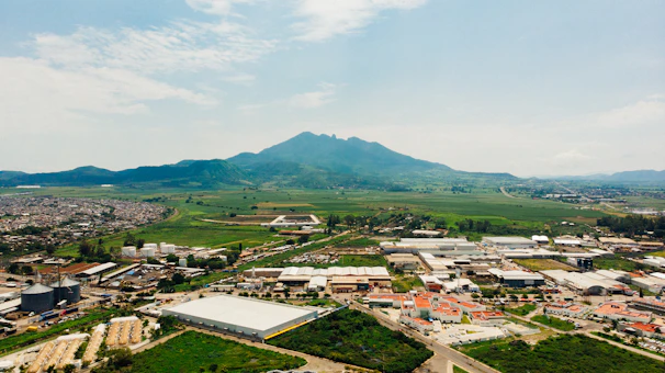 Aerial view of the manufacturing plant surrounded by green fields under a clear sky.