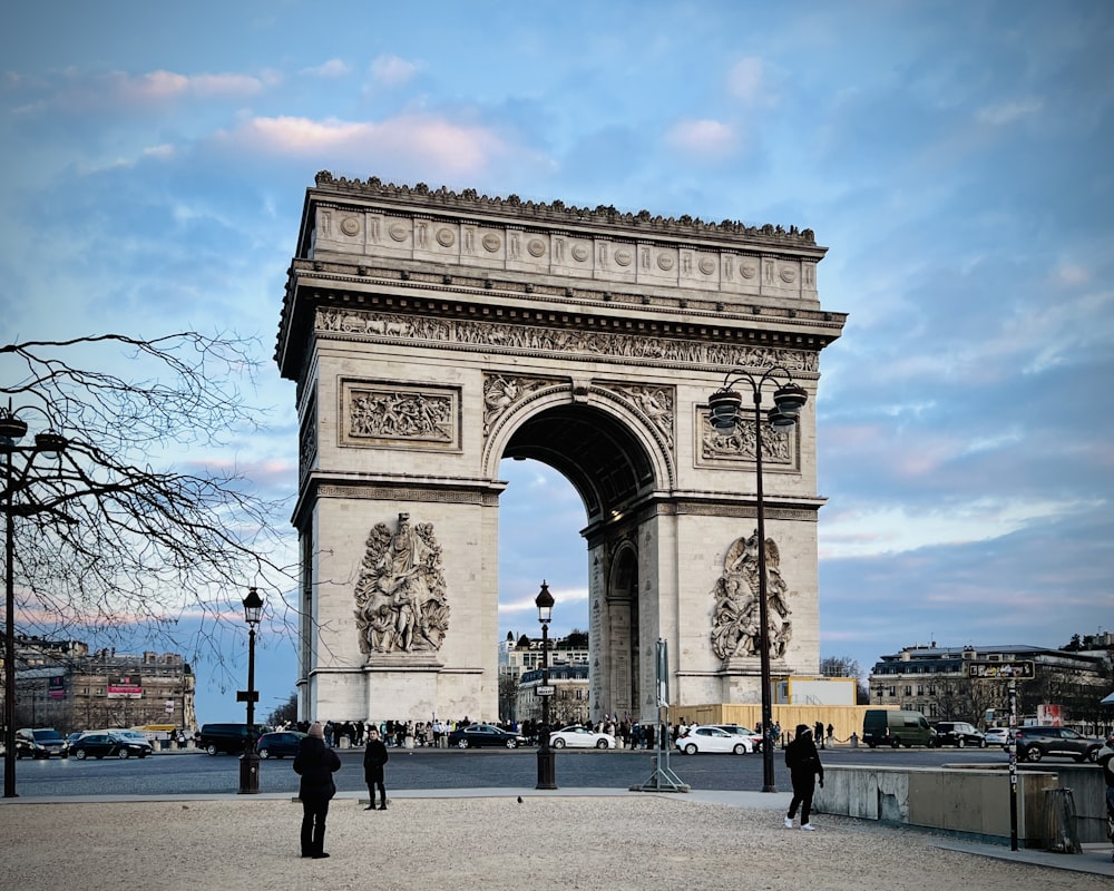 a group of people standing in front of a large arch