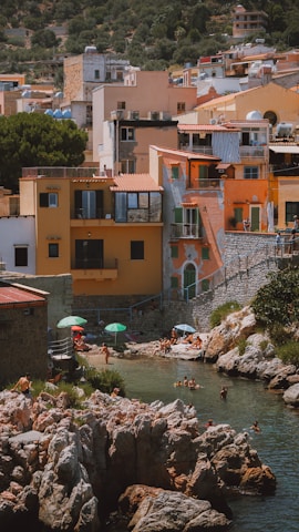 A vibrant shoreline village with bustling shops, a hotel, and people enjoying the seaside atmosphere.