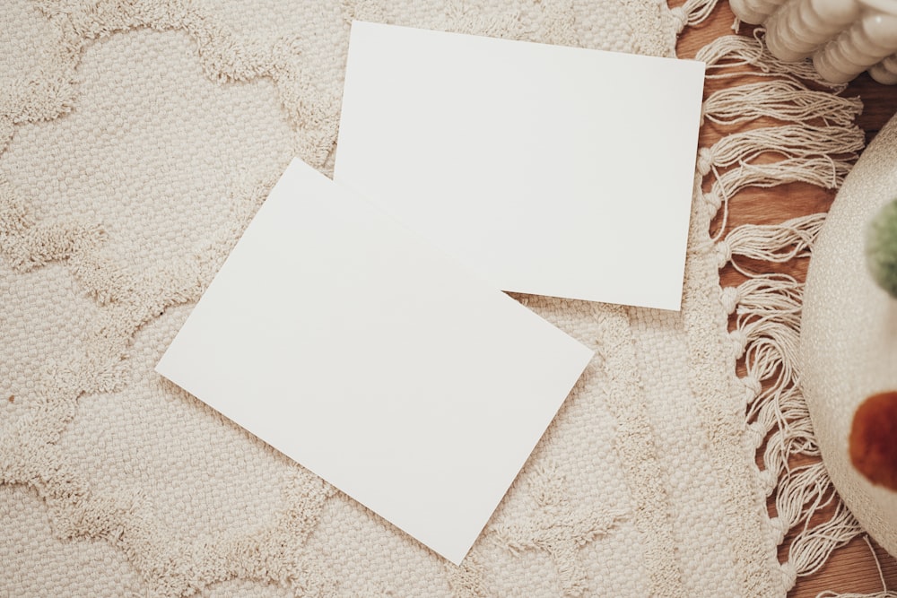two pieces of white paper sitting on top of a rug