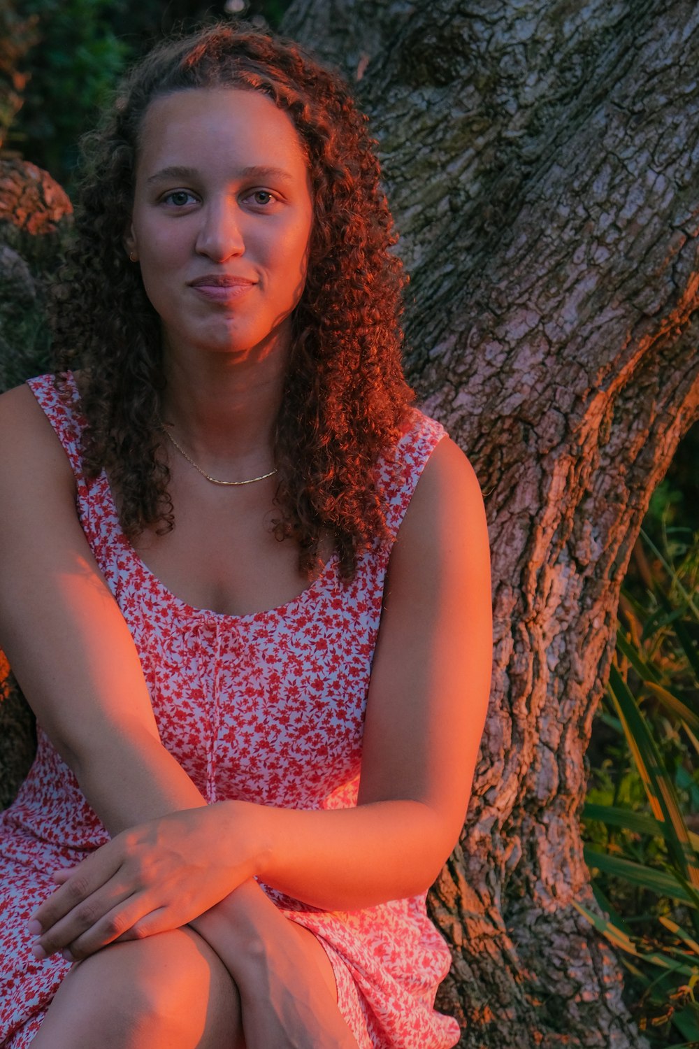 a woman in a dress sitting on a tree