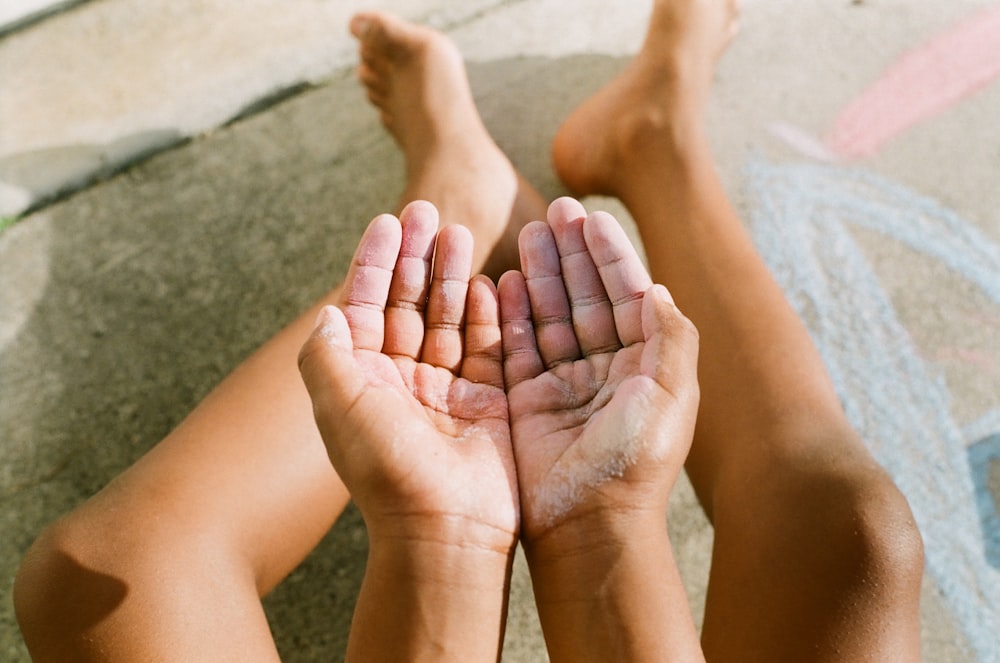 a person laying on the ground holding their hands together