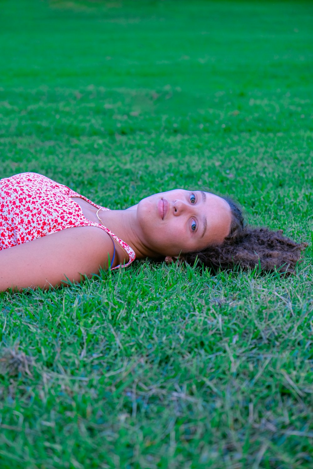 a girl laying on the grass with a frisbee in her hand
