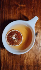 Close-up of a steaming cup of masala tea with spices on a wooden table.