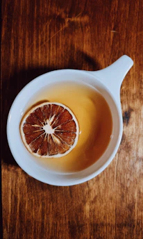 Close-up of a steaming cup of masala tea with spices on a wooden table.