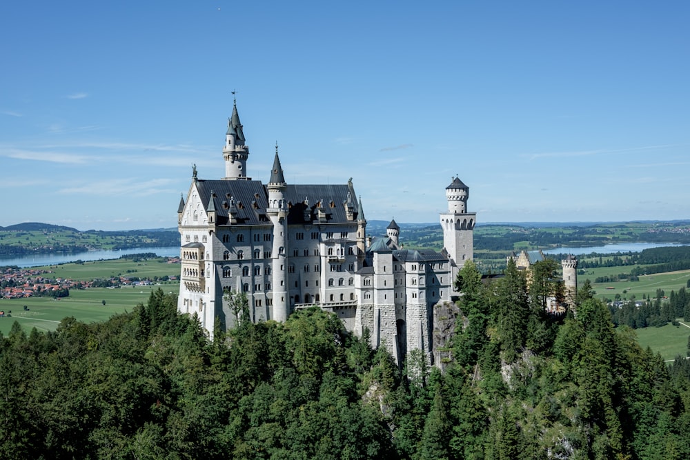 a large castle sitting on top of a lush green hillside