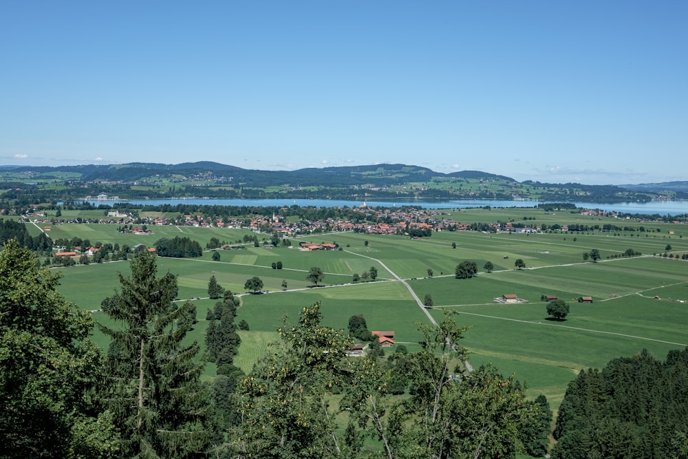 a scenic view of a green valley with a lake in the distance