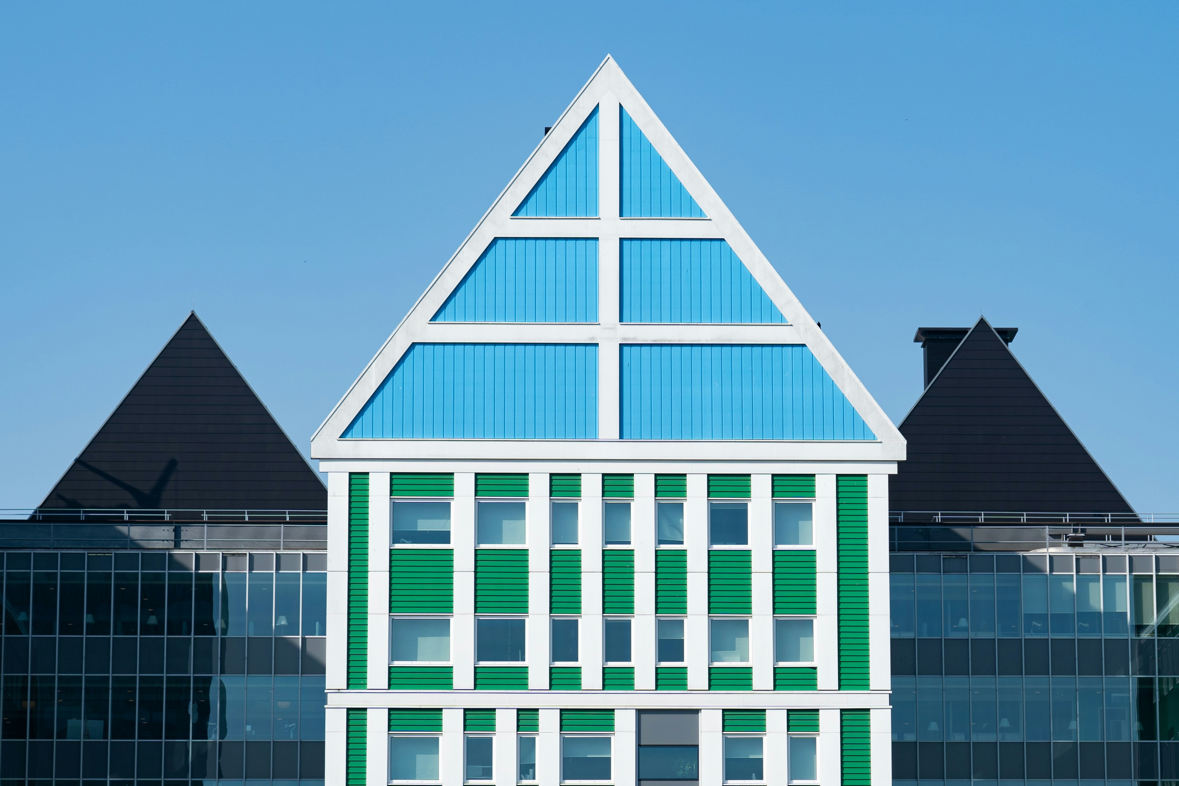 a green and white building with a black roof