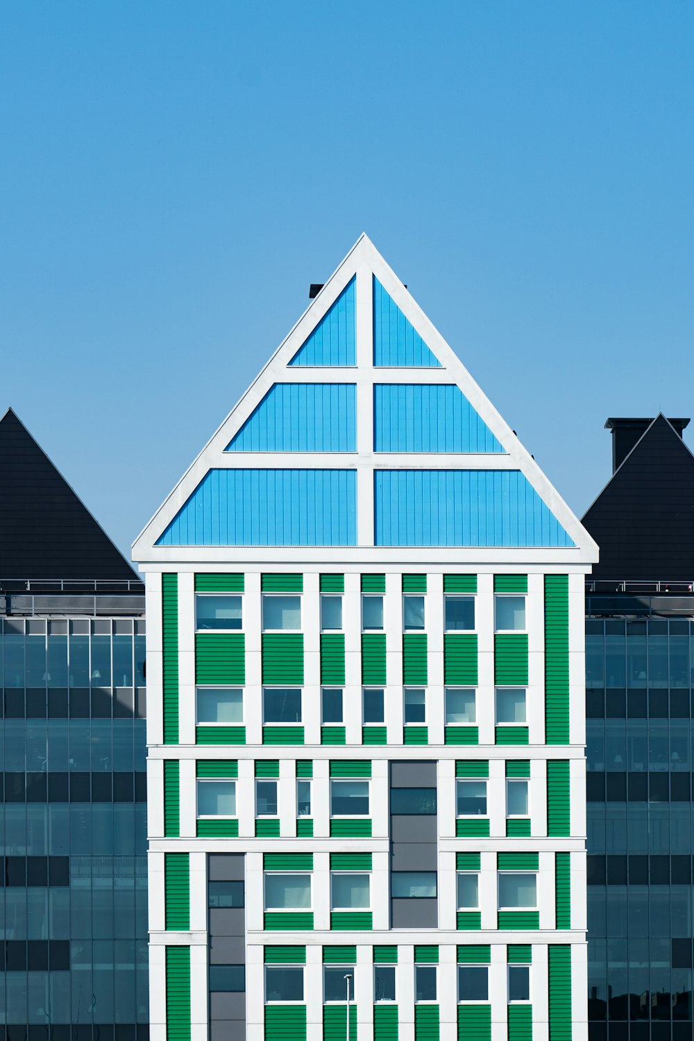 a green and white building with a blue roof