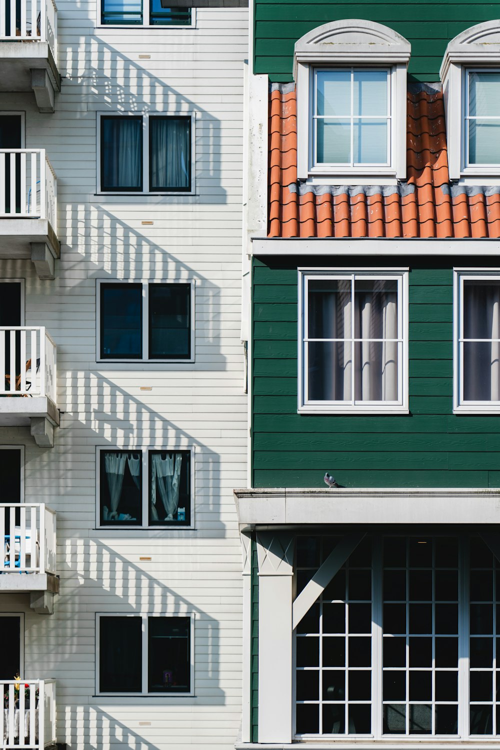 Un edificio verde y blanco con balcones y ventanas