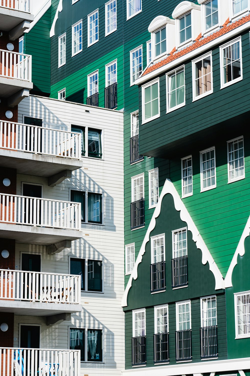 Un edificio verde y blanco con balcones y balcones