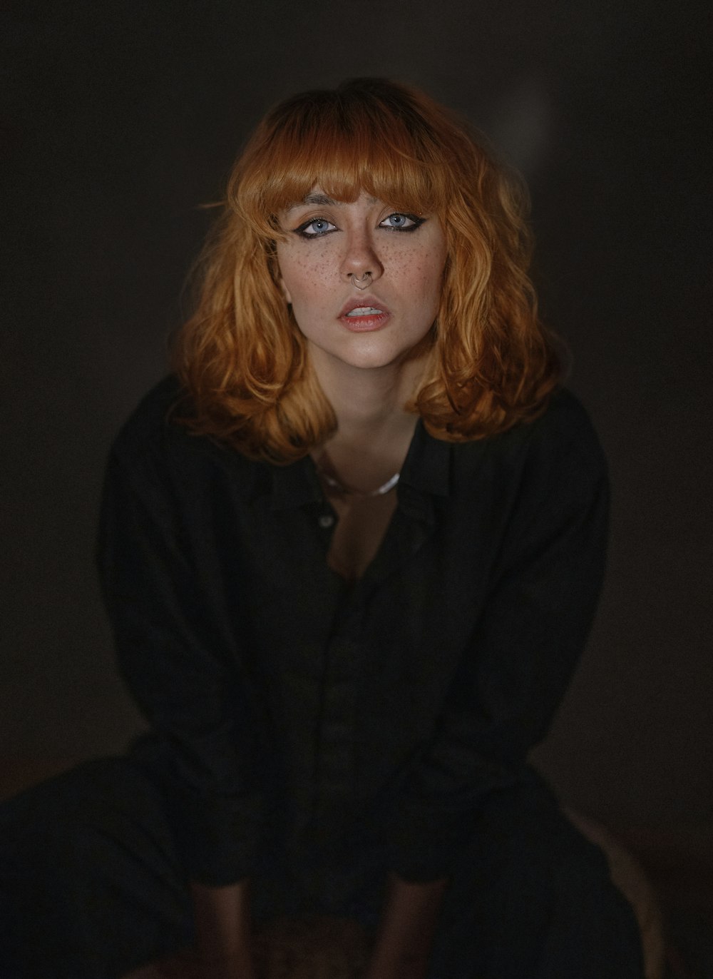 a woman with red hair sitting on a chair