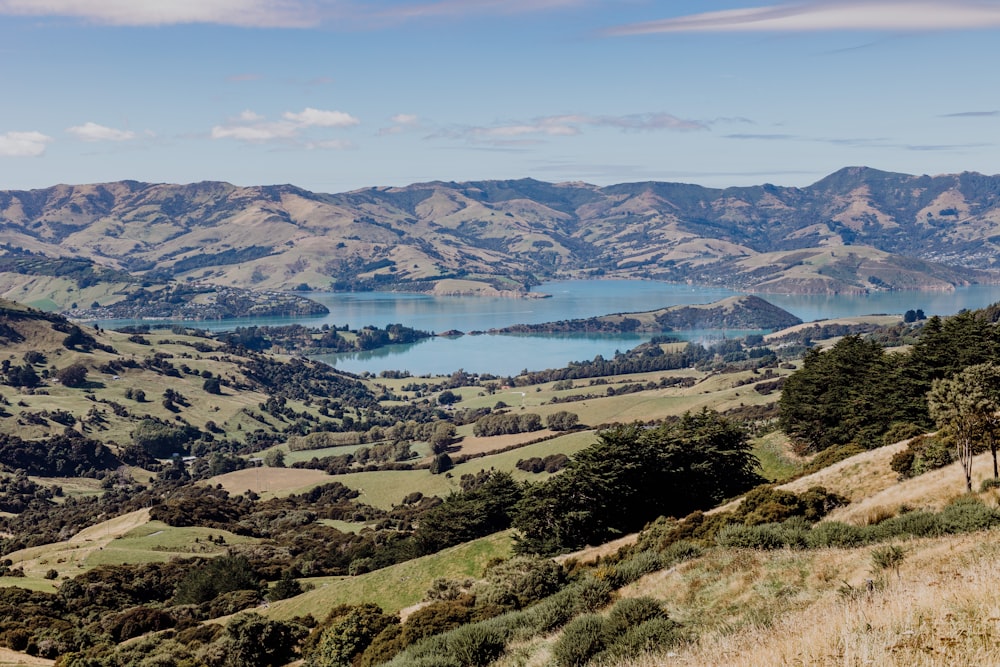 a scenic view of a mountain range with a lake in the distance