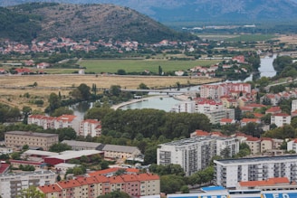 A scenic view of Bansko town surrounded by mountains, featuring apartment buildings ripe for investment.