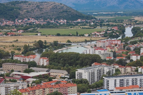 A scenic view of Bansko town surrounded by mountains, featuring apartment buildings ripe for investment.