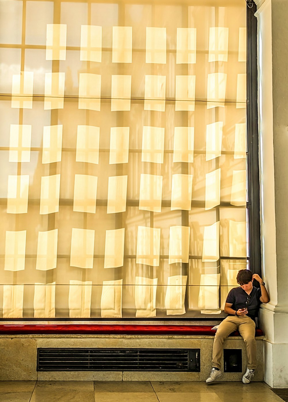 a man sitting on a bench in front of a window