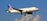 A commercial airplane with the United Airlines logo is flying against a backdrop of a clear blue sky with some clouds. The aircraft is white with blue and gold accents, and its wings are spread wide.