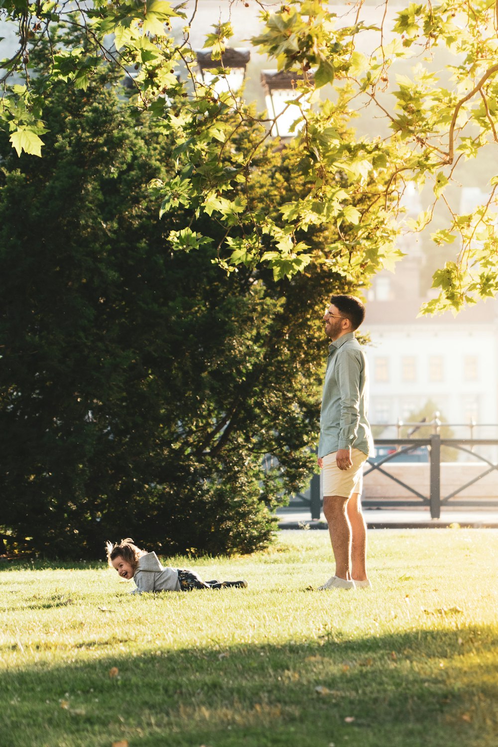 a man standing next to a little boy on a lush green field