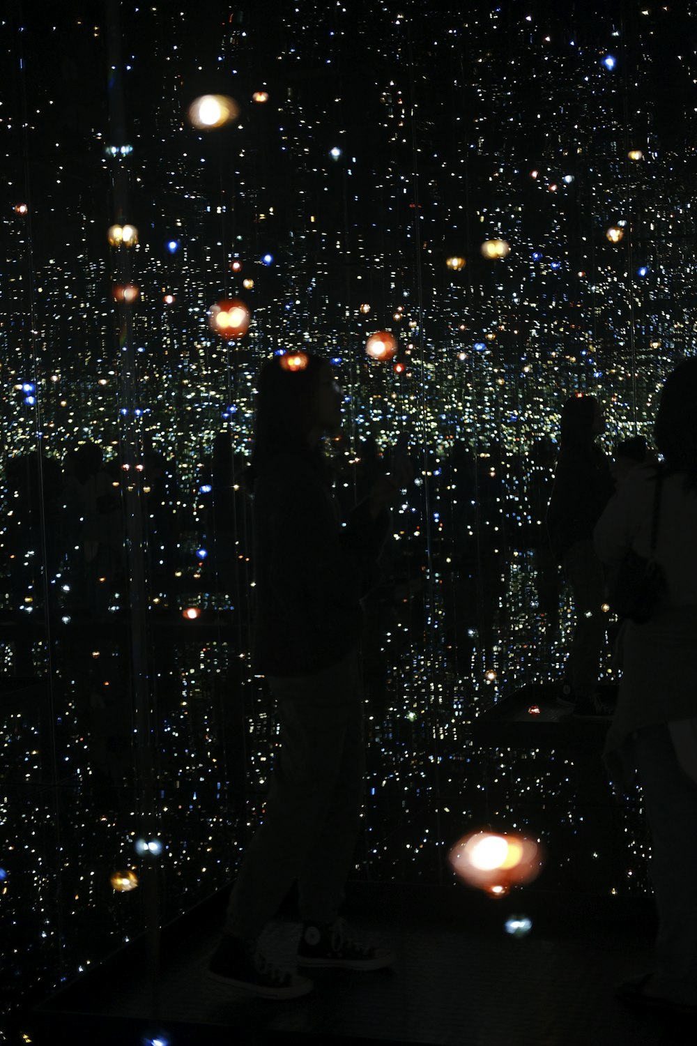 a group of people standing around a room filled with lights